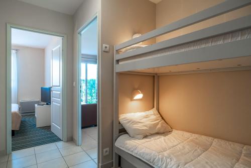 En eller flere senge i et værelse på Les Thermes 402 - Appt avec piscine commune