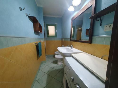 a bathroom with a sink and a toilet at CosmoCom Moradias Residence Capo Verde in Santa Maria