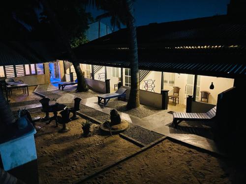 einen nächtlichen Blick auf eine Terrasse mit Bänken und Bäumen in der Unterkunft Winston Sea Front Villa in Negombo