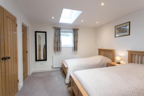 a bedroom with two beds and a window at Cornish Views in Camborne
