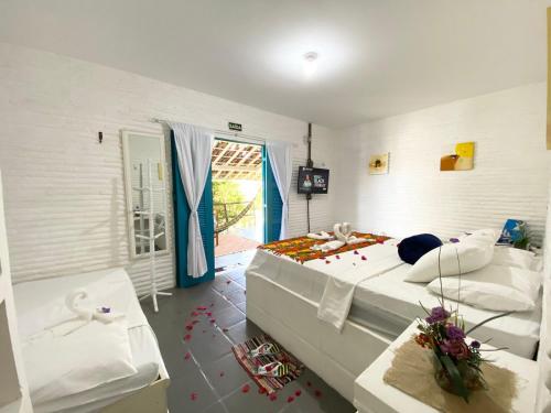 a bedroom with a bed with confetti on the floor at Pousada & Food 3 Abelhas in Cumbuco