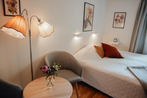 una camera d'albergo con letto, sedia e tavolo di Äspögården Bed & Breakfast a Klagstorp