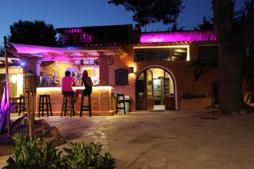 two people standing at a bar at night at Finca Can Toni in Sant Jordi
