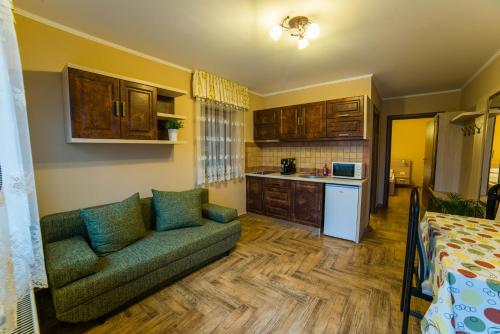a living room with a couch and a kitchen at Németh Resort in Sovata