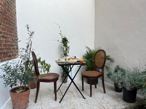 une petite table avec deux chaises et des plantes sur la terrasse dans l'établissement Le Clos Fleuri - 43m2 appartement calme avec jardin - 15 mns du centre de Paris, à Fontenay-sous-Bois