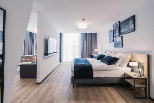 Habitación de hotel con cama y TV en YParc Hôtel, en Yverdon-les-Bains