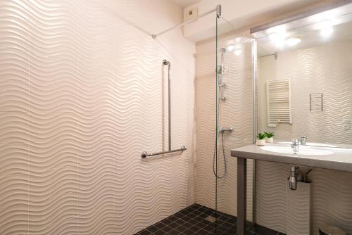 une salle de bain avec douche et lavabo dans l'établissement Les Thermes 500 - Appt avec piscine partagée, à Concarneau