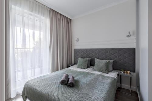 a bedroom with a bed with two pairs of slippers on it at Golden Apartments Warsaw - Luxury And Bright Apartment - Siedmiogrodzka 3 in Warsaw