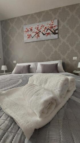 - une chambre avec un grand lit et une couverture blanche dans l'établissement Vespucci Holiday, à Casteldaccia