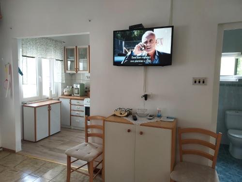 a kitchen with a tv hanging on the wall at Beach House in Betina