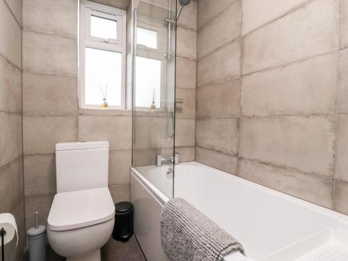 a bathroom with a toilet and a tub and a sink at 3 Thrimby Court in Morecambe