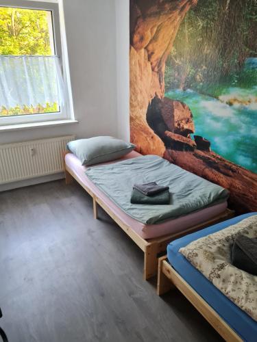 two beds in a room with a painting on the wall at Monteurwohnung Kuhfelde in Kuhfelde