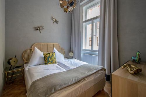 ein kleines Schlafzimmer mit einem Bett und einem Fenster in der Unterkunft 3BDR Oasis in the heart of Prague in Prag