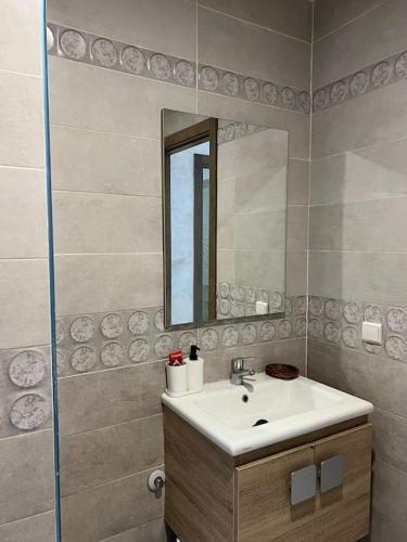 a bathroom with a sink and a mirror at Appartement Chaleureux et Cosy Proche De sortie autoroute in Mohammedia