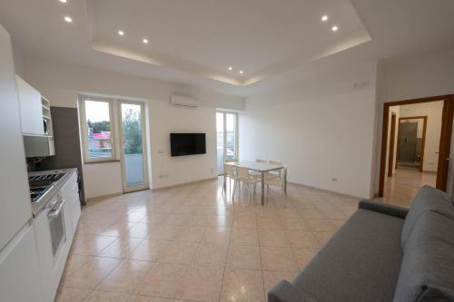 eine Küche und ein Wohnzimmer mit einem Sofa und einem Tisch in der Unterkunft Capodichino Airport Home By Dimorra in Neapel