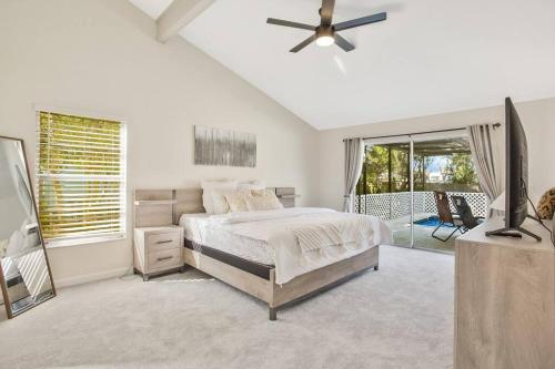a white bedroom with a bed and a balcony at Naples Oasis in Naples