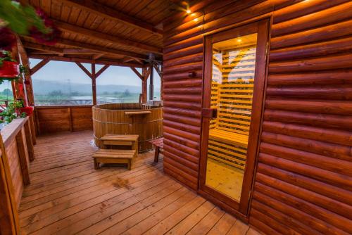 a wooden room with a chair and a wooden door at Németh Resort in Sovata
