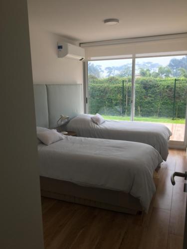 2 camas en un dormitorio con ventana grande en Mansa Inn 2 en Punta del Este