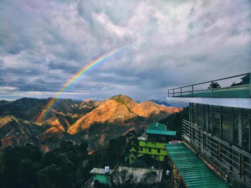 a rainbow in the sky over a mountain at Vintage Woods Inn in Shimla