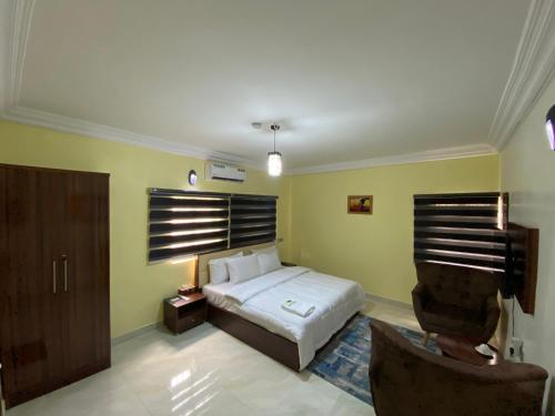 1 dormitorio con 1 cama y 1 silla en MOK Apartments & Suites, en Lagos