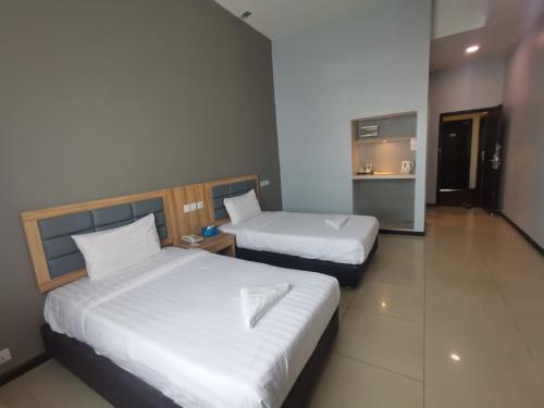 a hotel room with two beds and a kitchen at Kingston Executive Hotel in Tawau