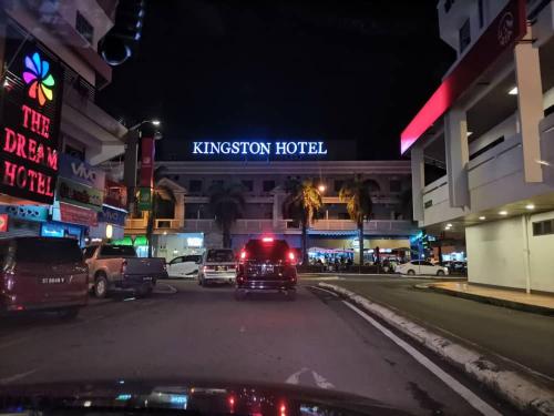 un camión estacionado en frente de un hotel Kingsbury por la noche en Kingston Executive Hotel en Tawau