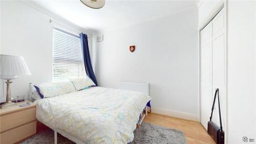 een kleine slaapkamer met een bed en een raam bij Charming 2-Bedroom Flat in the Heart of Cro London ER1 in South Norwood