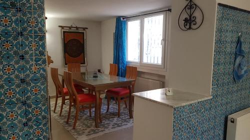 Villa Azaiiza في سوسة: غرفة طعام مع طاولة وكراسي ونافذة