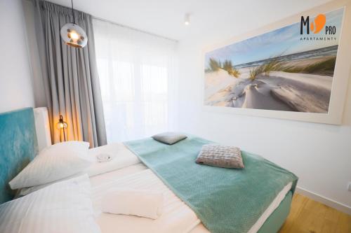 een slaapkamer met een bed met een deken erop bij Westin House Resort by MS Pro in Kołobrzeg