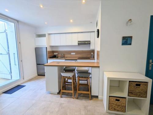 a kitchen with a counter and stools in a room at Entre calanques et vieux port ! in La Ciotat