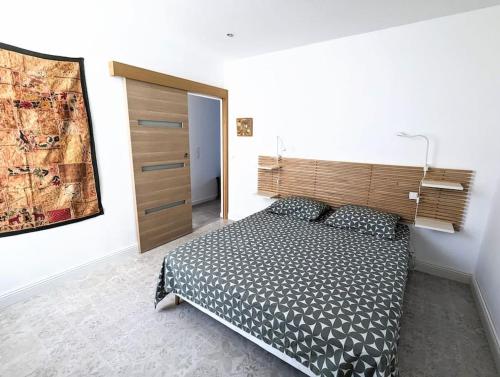 a bedroom with a bed with a wooden headboard at Entre calanques et vieux port ! in La Ciotat