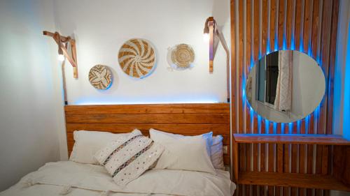 a bedroom with a wooden headboard and a mirror at Paddle Out Morocco in Tamraght Ouzdar