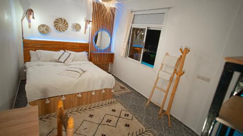 1 dormitorio con cama y ventana en Paddle Out Morocco, en Tamraght Ouzdar