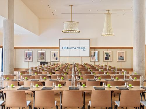 an empty lecture hall with tables and chairs at H10 Croma Málaga in Málaga