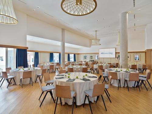 a banquet hall with white tables and chairs at H10 Croma Málaga in Málaga