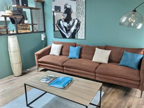 Sala de estar con sofá marrón y mesa de centro en Myzenplace - Duplex 100m2 cosy & atypique, centre piéton, parking, en Montélimar