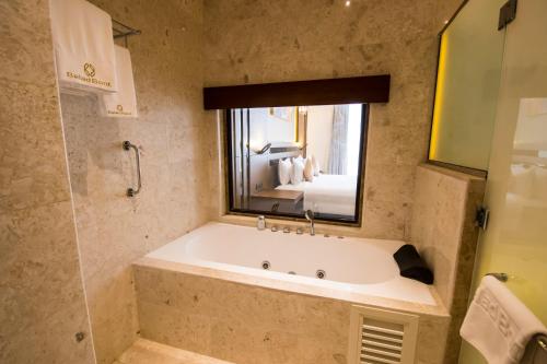 a large bath tub in a bathroom with a mirror at Belad Bont Resort in Salalah