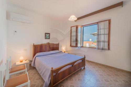um quarto com uma cama grande e uma janela em Casa Marida tra Cotoncello e Sant'Andrea - Goelba em SantʼAndrea