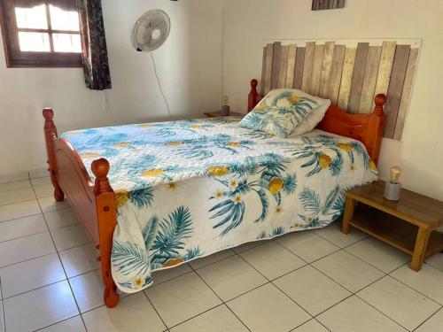 um quarto com uma cama com um edredão azul e branco em L'appartement FRUIT DE LA PASSION em Le Gosier