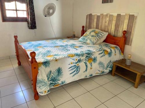 Un dormitorio con una cama con un edredón azul y blanco. en L'appartement FRUIT DE LA PASSION, en Le Gosier
