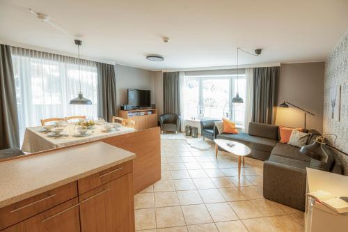 a living room with a couch and a table at Panorama Spa Lodges DAS.SCHILLER in Bad Gastein