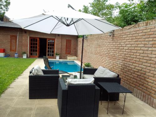 an umbrella and chairs next to a swimming pool at Alquiler temporario Santo Tome in Santo Tomé