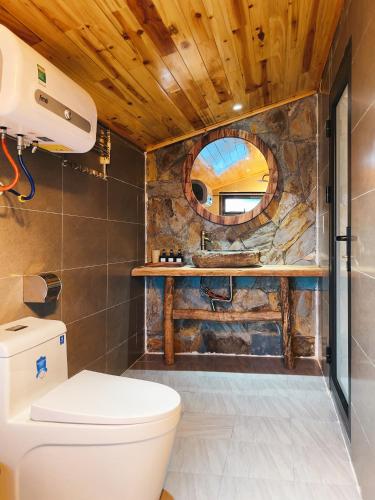 a bathroom with a toilet and a mirror at Ap Retreat - Ta Van's Heel in Sapa