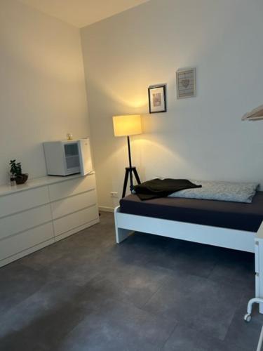 um quarto com uma cama com um candeeiro e uma televisão em Apart das Ehrets em Bretzfeld