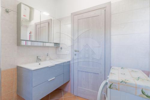 uma casa de banho com uma porta azul e um lavatório em Casa Marida tra Cotoncello e Sant'Andrea - Goelba em SantʼAndrea