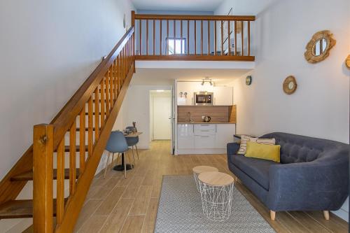- un salon avec un canapé bleu et un escalier dans l'établissement Superbe Loft entre la gare et vieux port, à Marseille