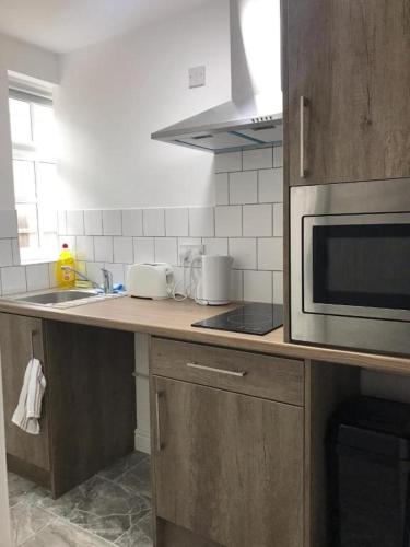 a kitchen counter with a microwave and a sink at ASM - Luxury Two Bedroom Apartment in Leicester