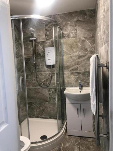 ein Bad mit einer Dusche, einem WC und einem Waschbecken in der Unterkunft ASM - Luxury Two Bedroom Apartment in Leicester