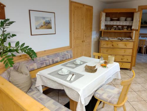 a dining room with a white table and chairs at Garni Hattlerhof B&B in Brunico
