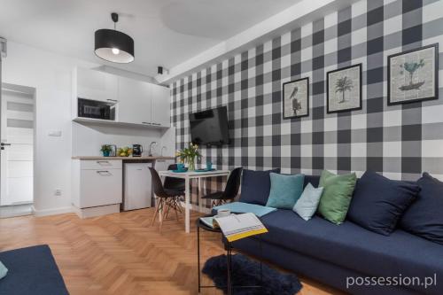 uma sala de estar com um sofá azul e uma cozinha em Mikrokawalerki w sercu Gdańska em Gdansk